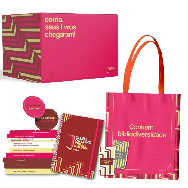 Box Clube do Livro 2026 com 10 livros de capa dura e brindes exclusivos (planner, ecobag, marcadores, caderno, vela e xícara) sobre uma mesa de madeira, iluminação natural suave.